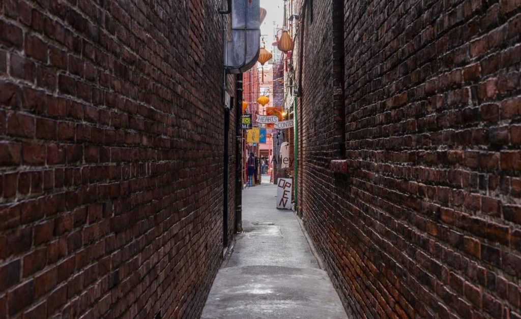 a view of Fan Tan Alley, with brick walls shops in the background, one of the best things to do in Victoria Canada