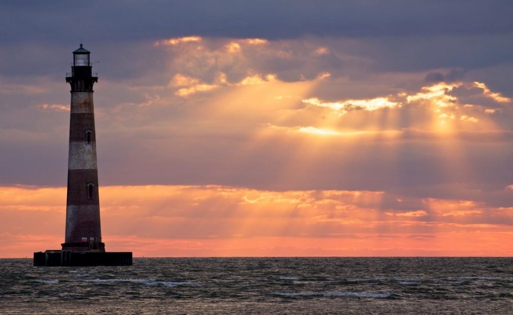 Morris Island Lighthouse with a sunset background, one of the best Charleston South Carolina attractions