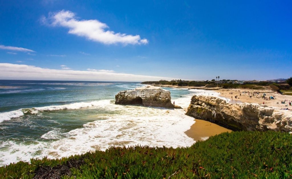 the beach at Santa Cruz with blue waters, gold sand and sunlight, an example of what you can see on California trips