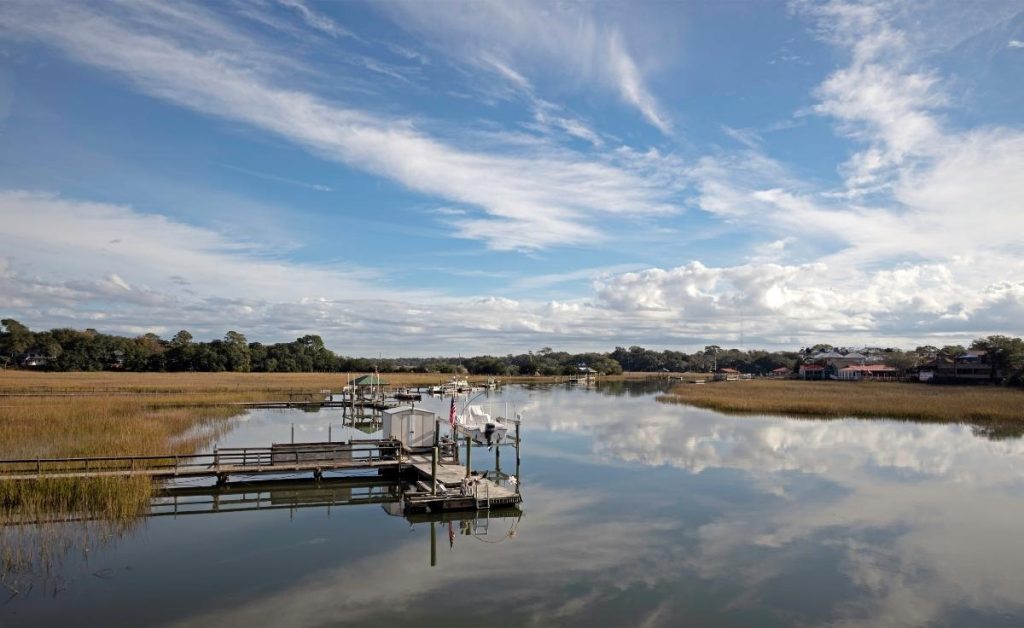 view of a large creek and marshlands with blue skies at Shem Creek park, one of the Charleston South Carolina attractions