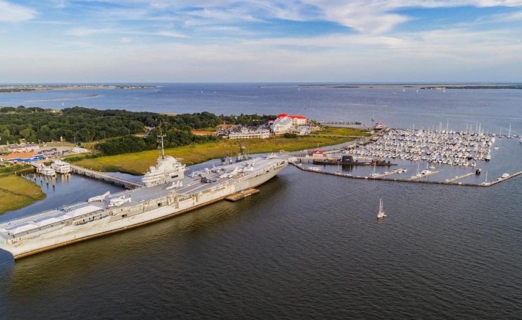 an aerial view of USS Yorktown with a war ship and boats in the harbor, in Charleston South Carolina