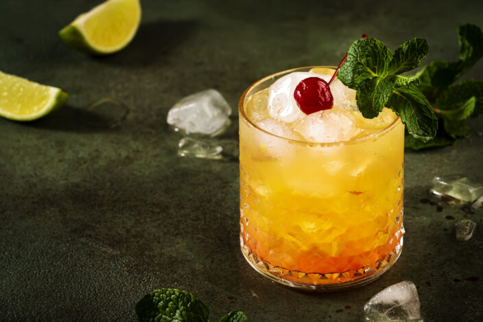 Mai Tai trendy alcoholic cocktail with rum, liqueur, syrup, lime juice, mint and crushed ice.