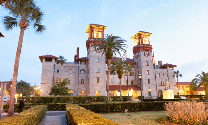 front view of the Lightner Museum with golden lights and light blue skies in St. Augustine downtown