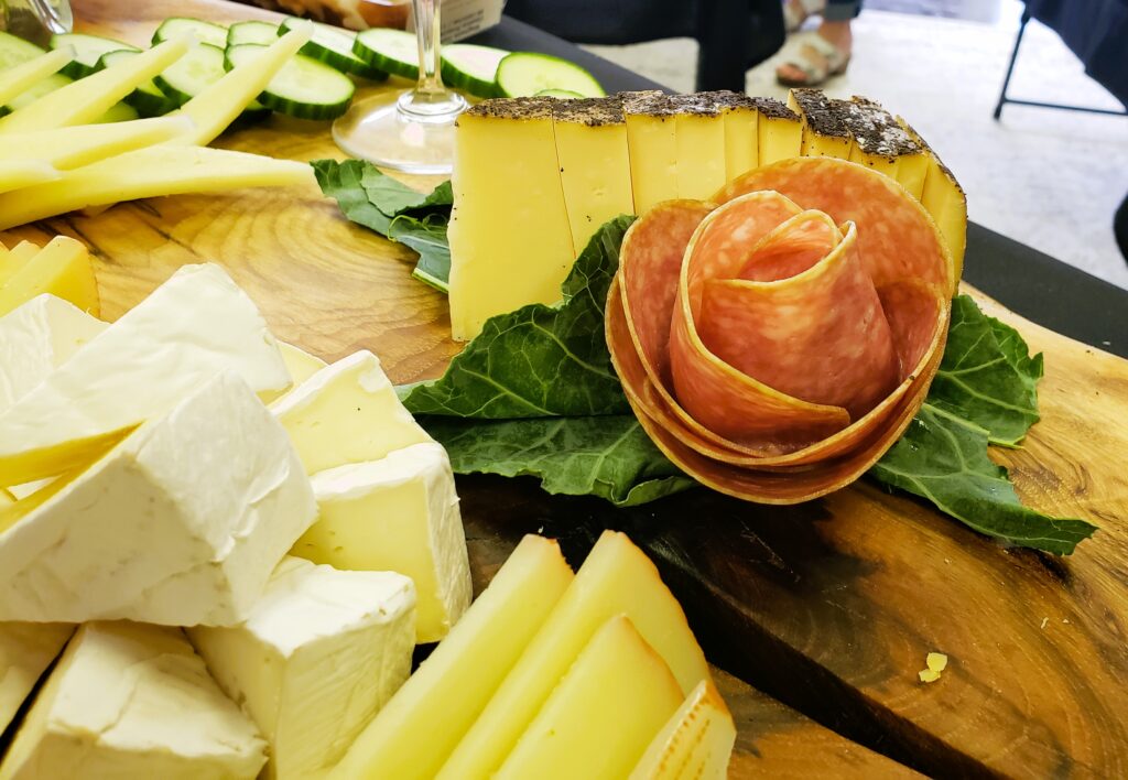 Cheeses and a meat rose on an exotic piece of wood