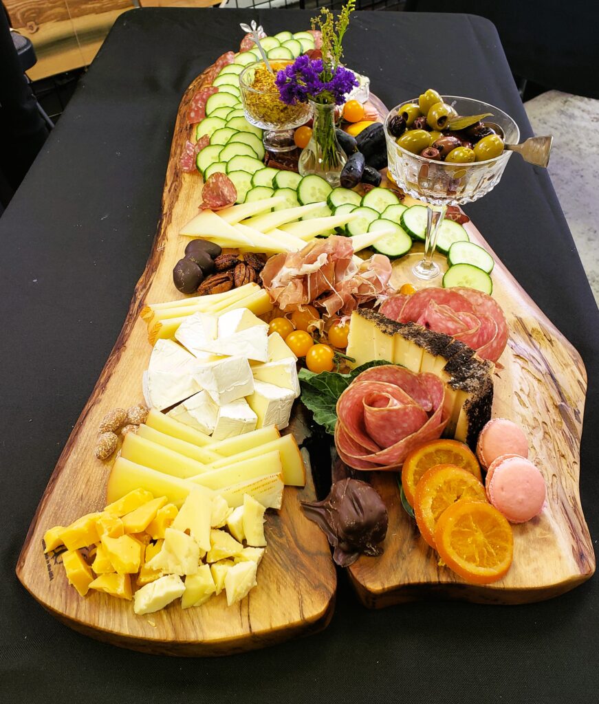 A large charcuterie board, filled with meats, cheeses, fruits, and cookies