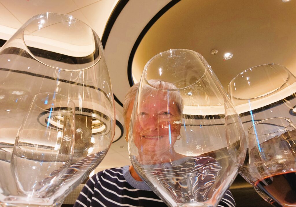 Writer, Jo, photographed through a row of wine glasses