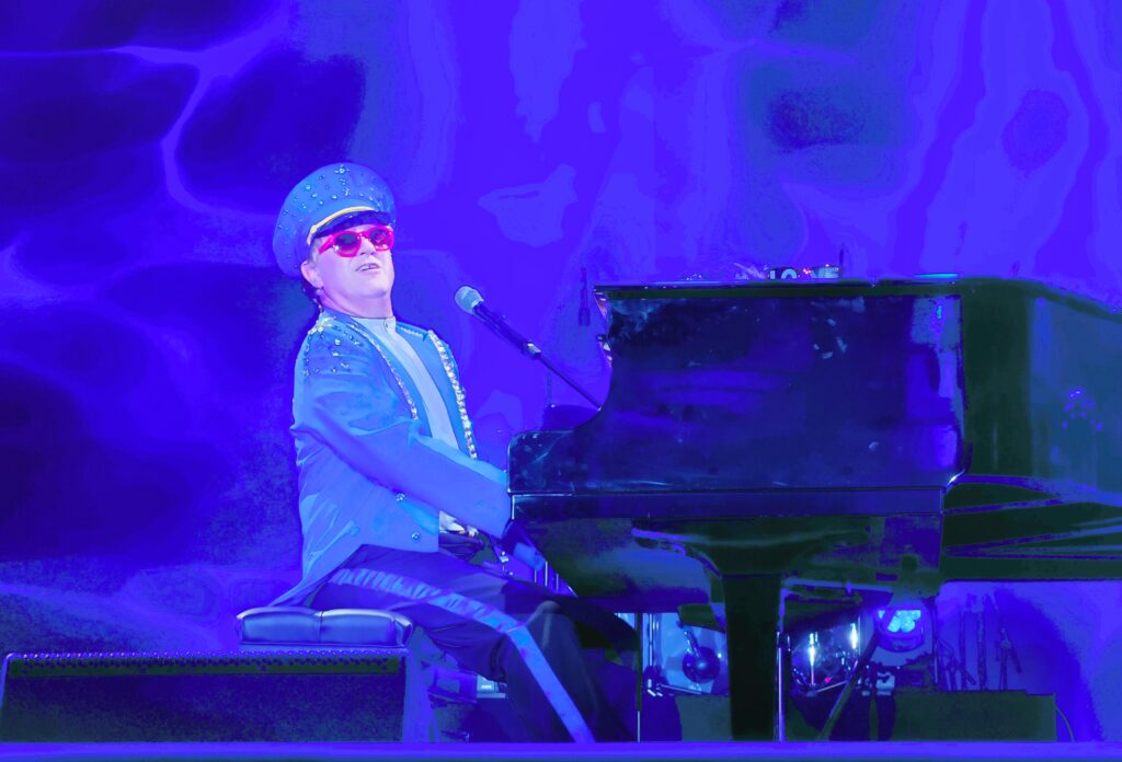 Elton John impersonator plays baby grand and sings
