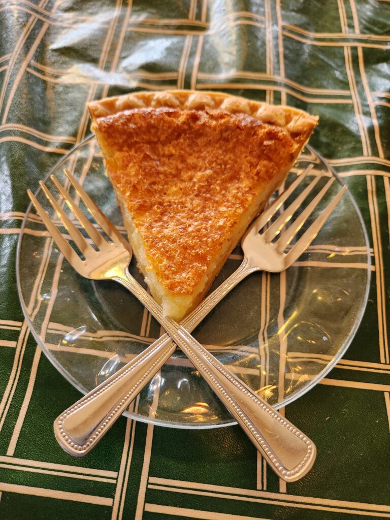 Slice of Buttermilk pie on plate with two forks