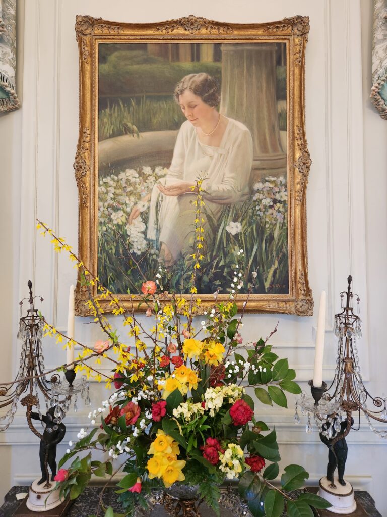 painting of Mrs. Calloway with a floral arrangement on table below