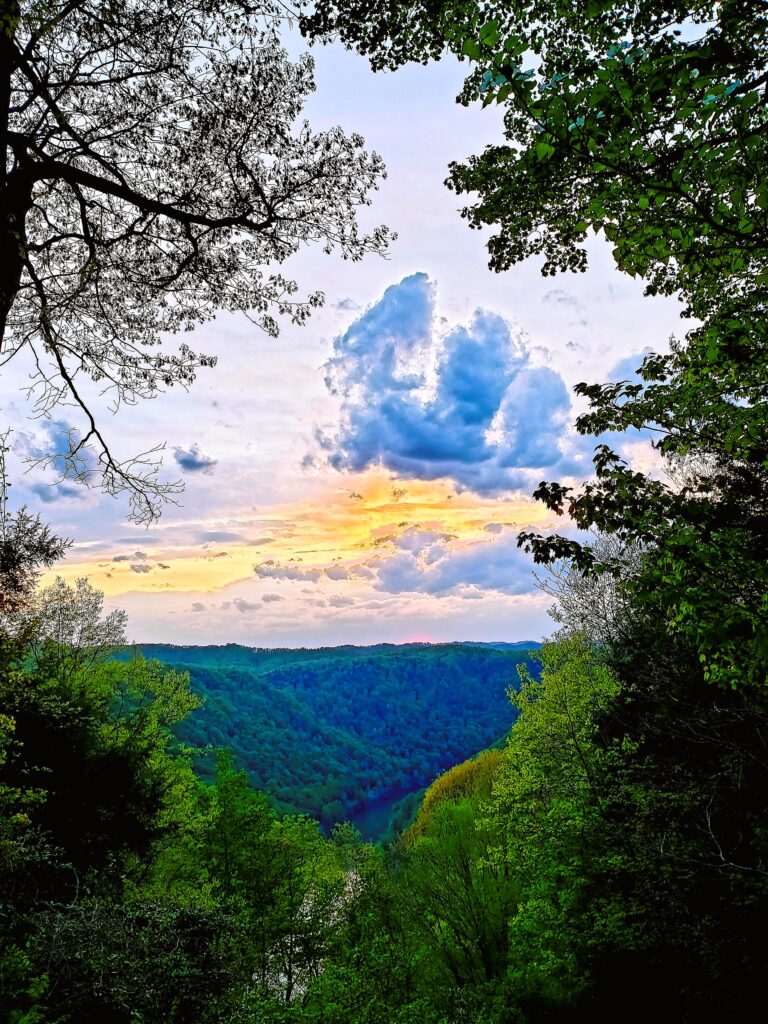 Sunrise coloring the West Virginia sky with mountains over the river