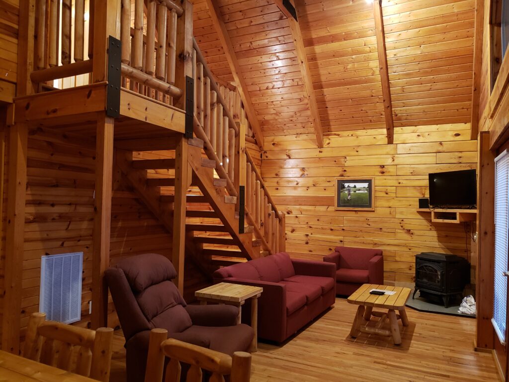 Living room and stairs to 2nd floor bedrooms in log cabin