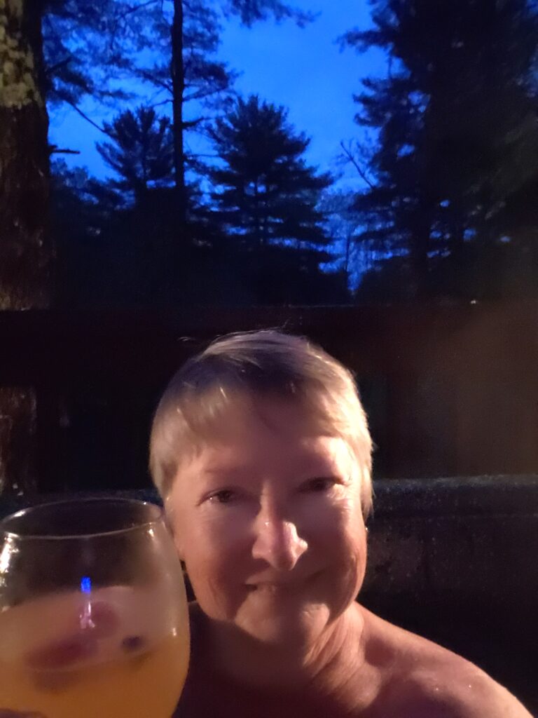 Woman in hot tub holding glass of cider