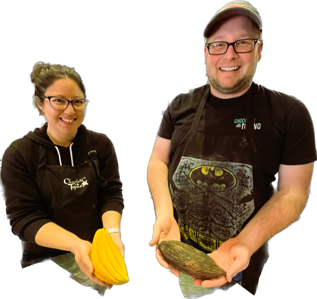 Owners of Chocolate Tofino, Kim holding a fresh cacao pod (bright yellow), husband Cam holding a dried cacao pod that is greenish brown and shriveled