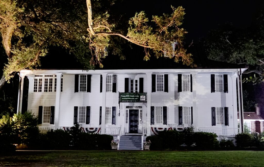 The Kaminski House at night - a large white two-story structure.