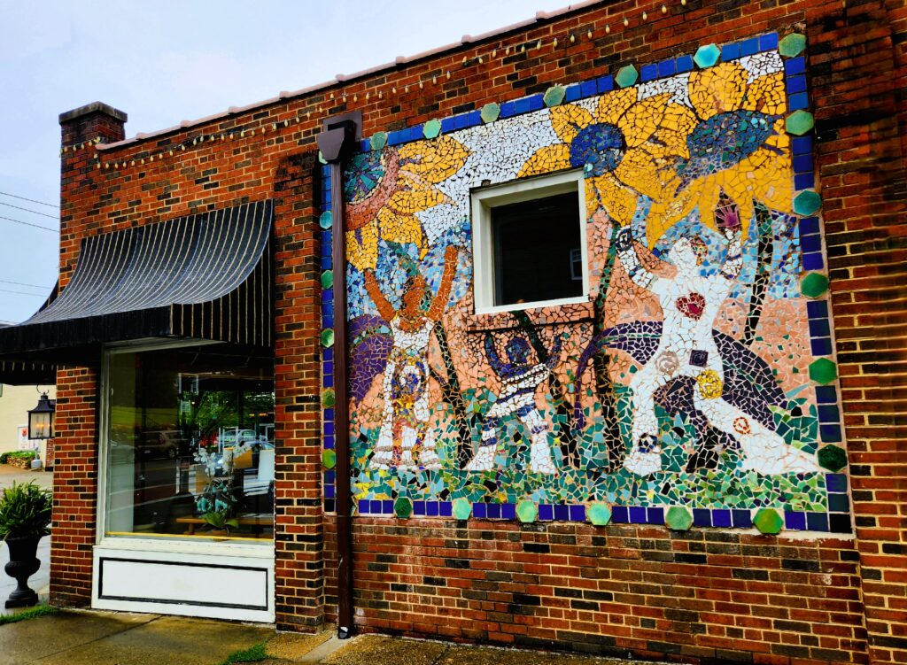 Roanoke's Reid's furniture and decor store has a colorful mural outside, sunflowers and people.