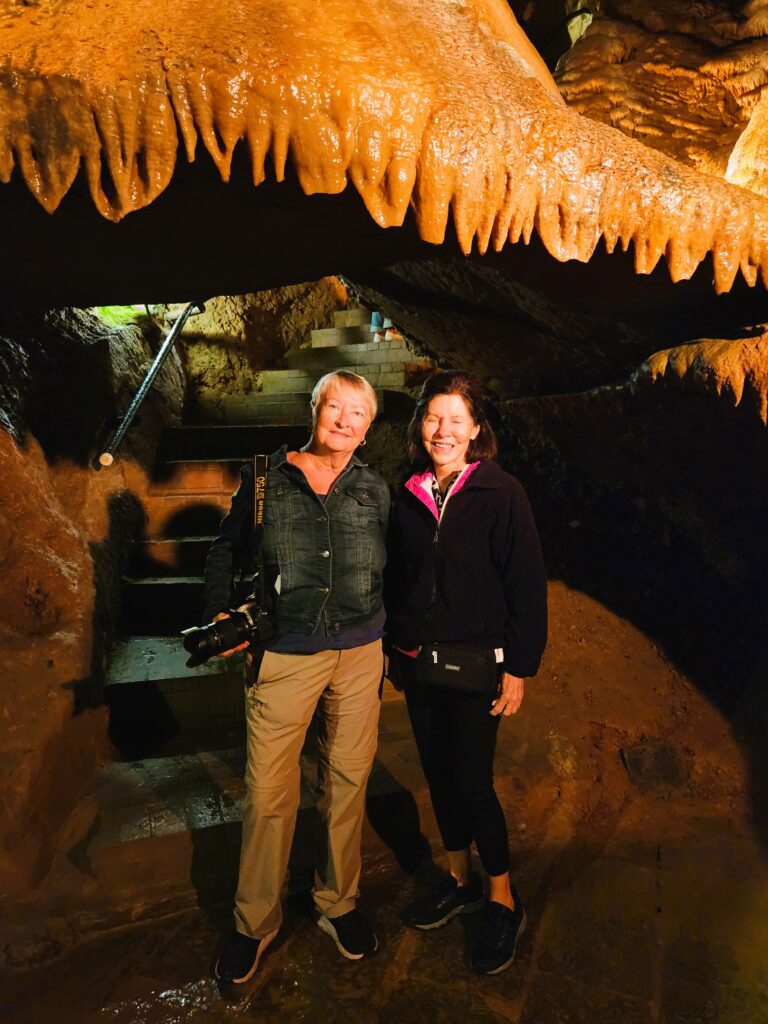 Two women under a large bell-shaped stalagtite in the cavern, supposedly if it drips on you, within the year you will wed! I suspect I just got wet!