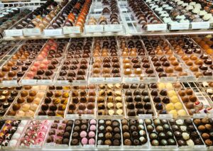 Rows and rows of chocolates in a glass candy case at a Roanoke chocolatier