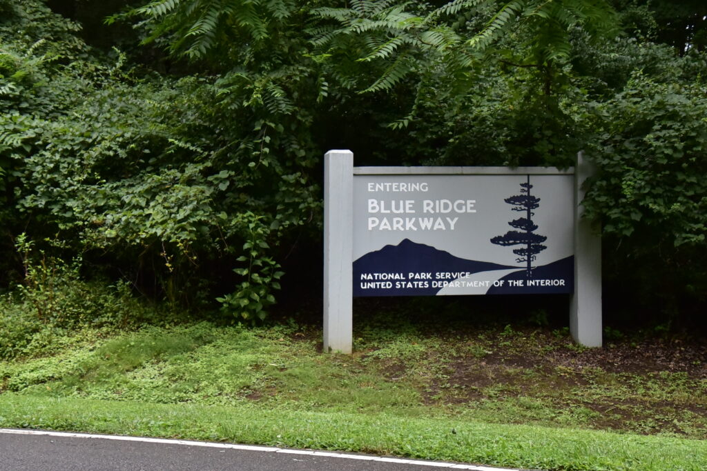 The Blue Ridge Parkway entrance sign, nearby is Roanoke's Mill Mountain Star.