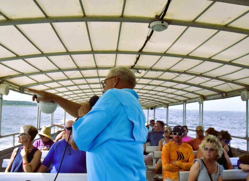 1st Mate Judd talking on his microphone as he points out places of interest, while the boat skims along the North Island coast.