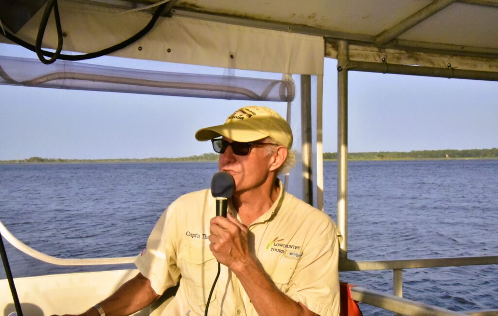 Capt'n Thom talking on his microphone as he steers the boat along the North Island coast, about an hour from Georgetown.