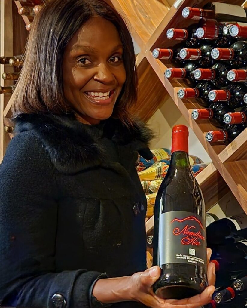 Maria, a beautiful Namibian lady holding a bottle of wine