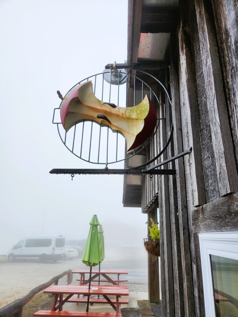 The Apple Core Grille sign at Altapass Orchard, which is a large apple core across a grill rack.