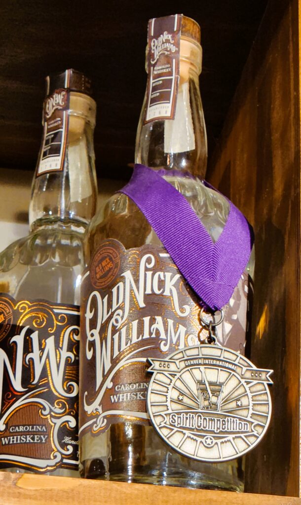 Bottles of Old Nick Williams with awards hanging around the neck of the bottle.