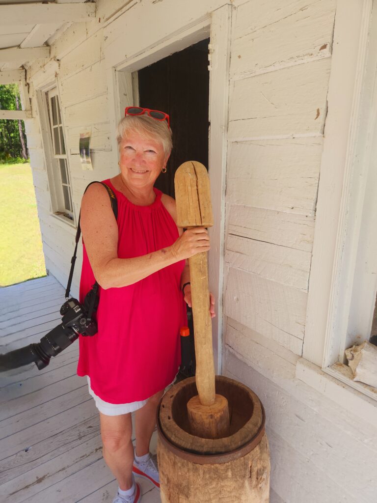 Writer, Jo, holds the pestle against a bowl like many women did before her to separate rice grains from the rice plant.