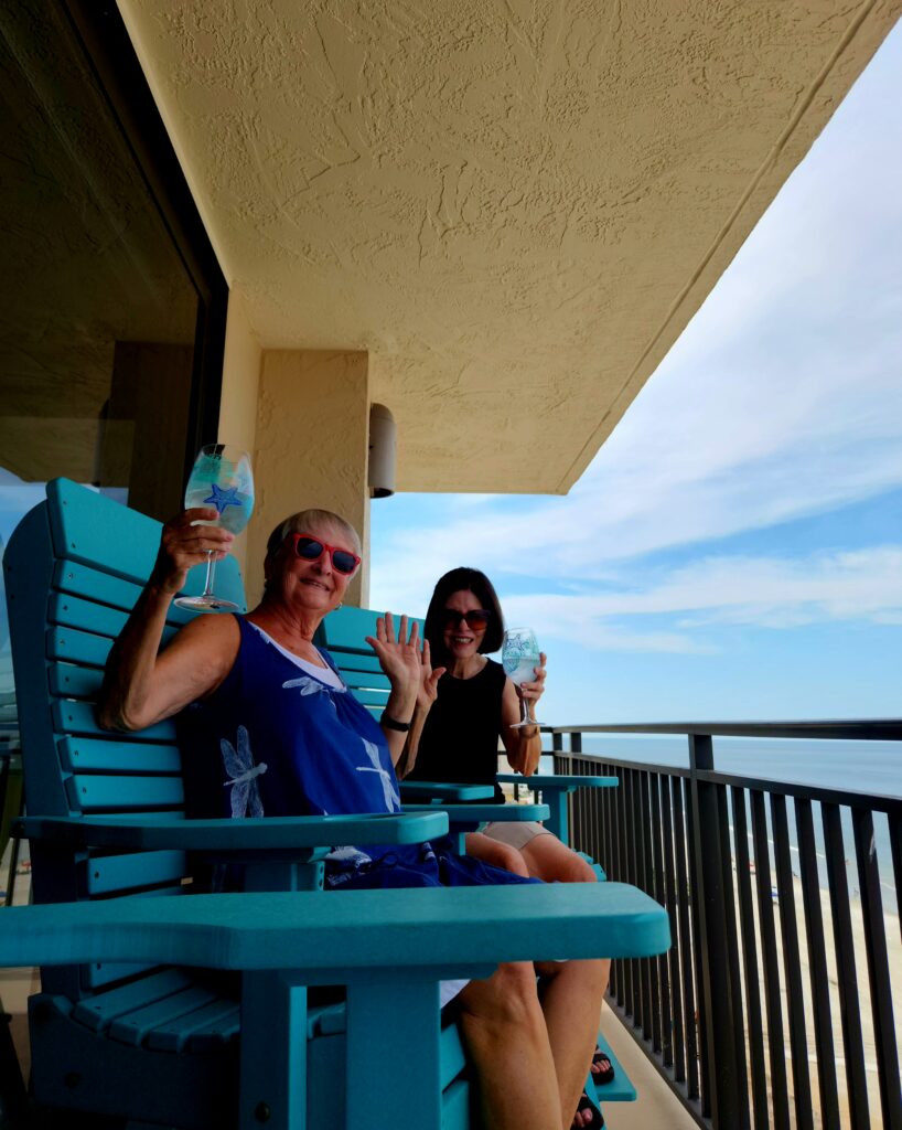 Jo and travel buddy celebrating the weekend with wine on the condo's oceanfront balcony.