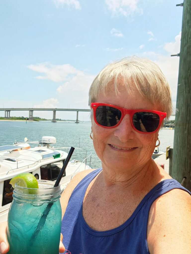 Jo with a Shark attack drink with the New Smyrna Beach bridge in the background.