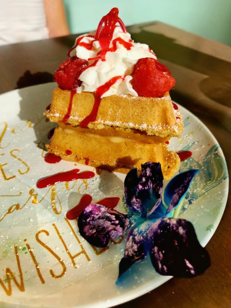 A strawberry shortcake waffle on a mermaid plate.
