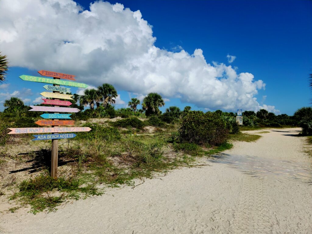 Old-fashioned, colorful directional signs at New Smyrna Beach's Smyrna Dunes Park.