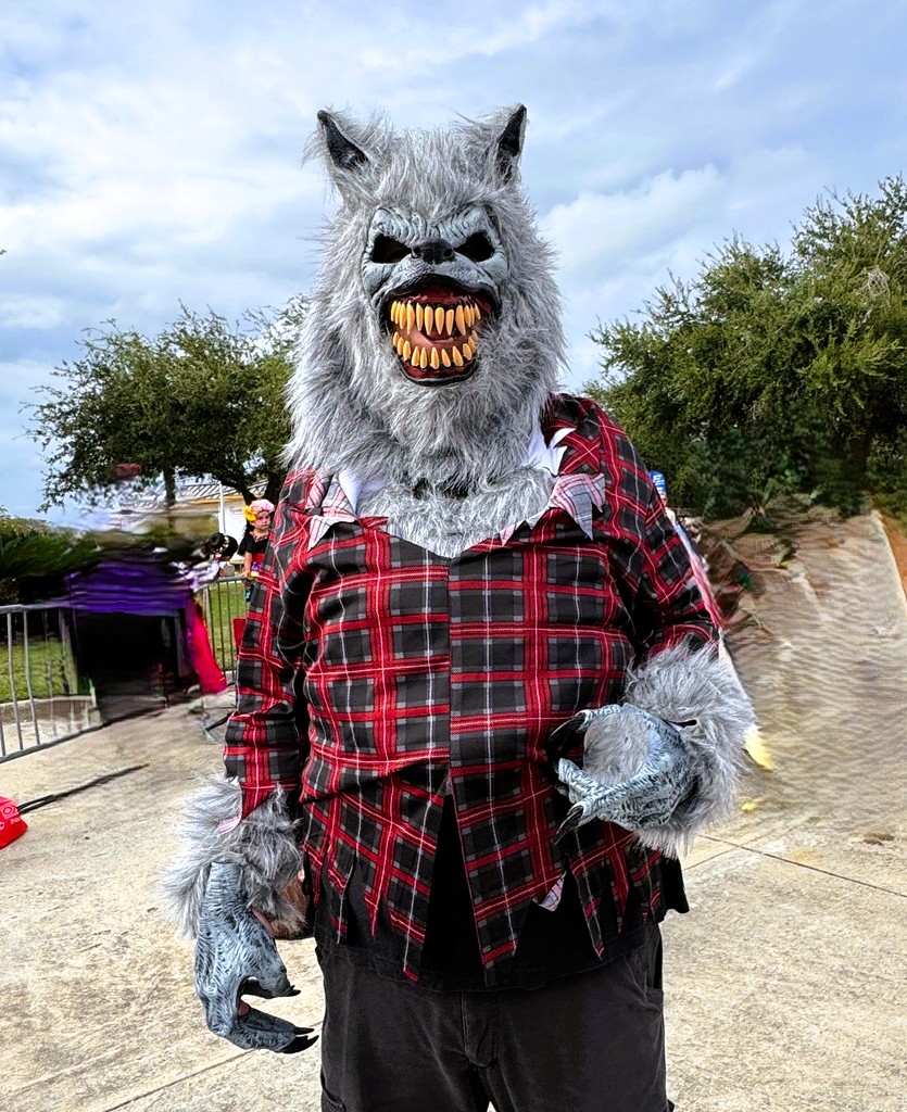 Person in a plaid shirt with a wolf's head on - a Rougarou on a haunted prowl.