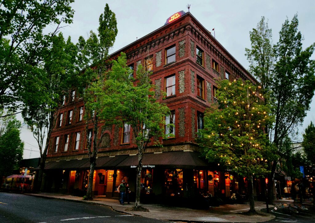 Spend 11 Awesome Days in the Willamette Valley 11 Brick 4-story hotel at dusk - with lights on, and twinkle lights in the trees.