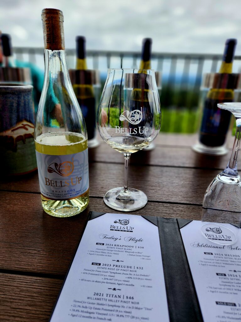 26 Sensational Must-Visit Oregon Wineries in the Willamette Valley 17 White wine and glass on porch table.