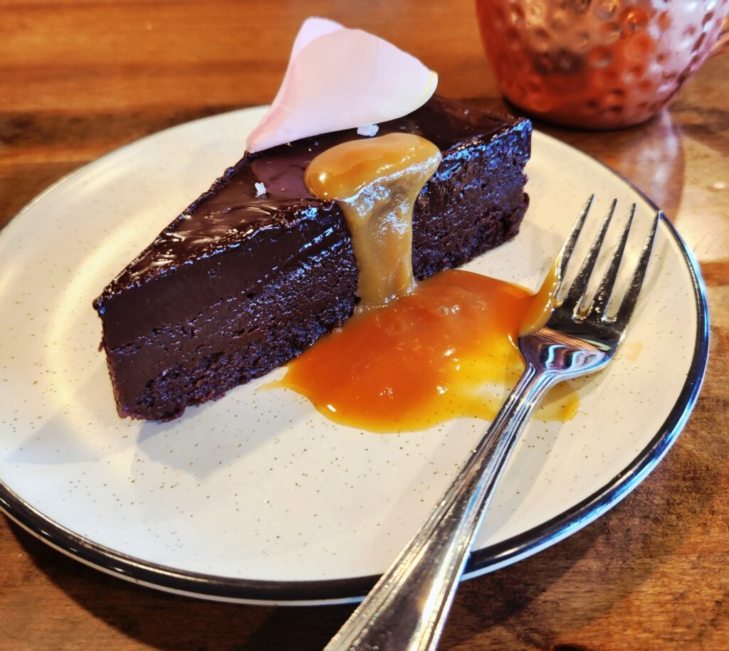Spend 11 Awesome Days in the Willamette Valley 34 A dark chocolate torte dripped in caramel sauce on a silver-edged dessert plate with a fork alongside.