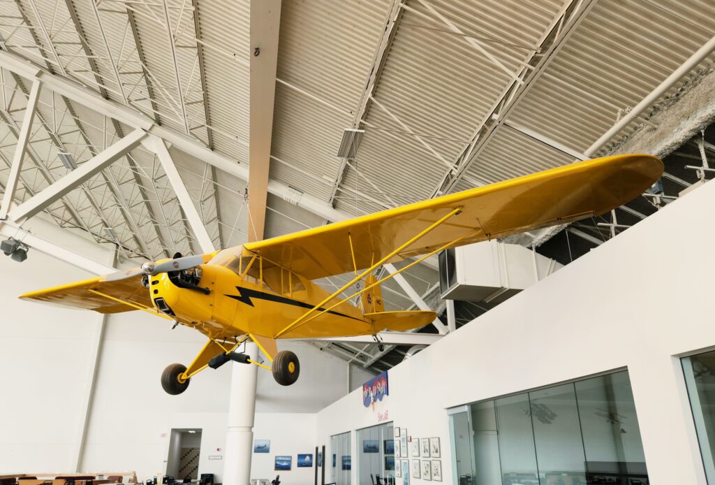 26 Sensational Must-Visit Oregon Wineries in the Willamette Valley 6 Yellow Piper Cub plane suspended from ceiling in museum.