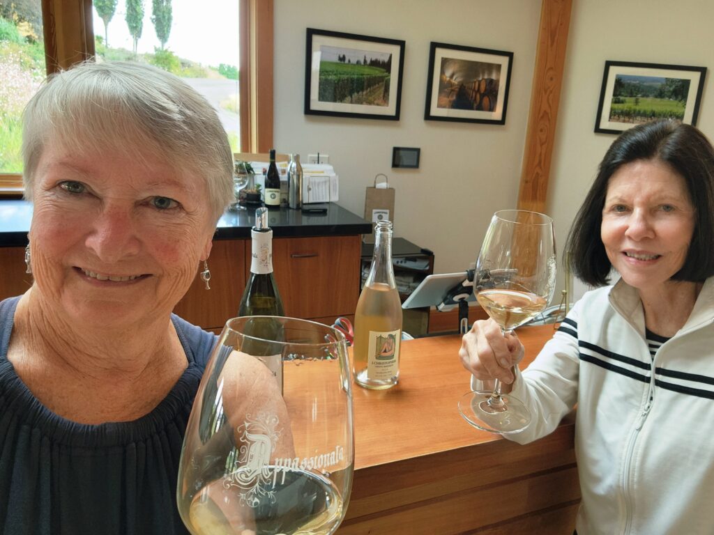 26 Sensational Must-Visit Oregon Wineries in the Willamette Valley 39 Two women toasting with a white wine.