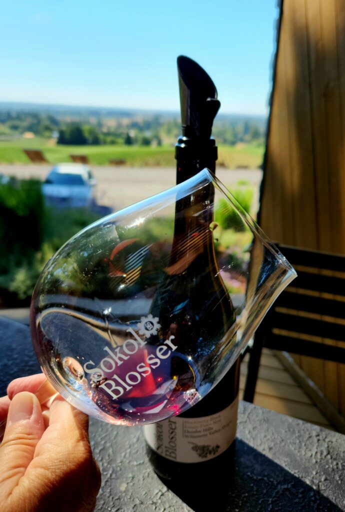 26 Sensational Must-Visit Oregon Wineries in the Willamette Valley 45 A close-up of Pinot Noir n a logo Sokol Blosser stemmed wine glass.