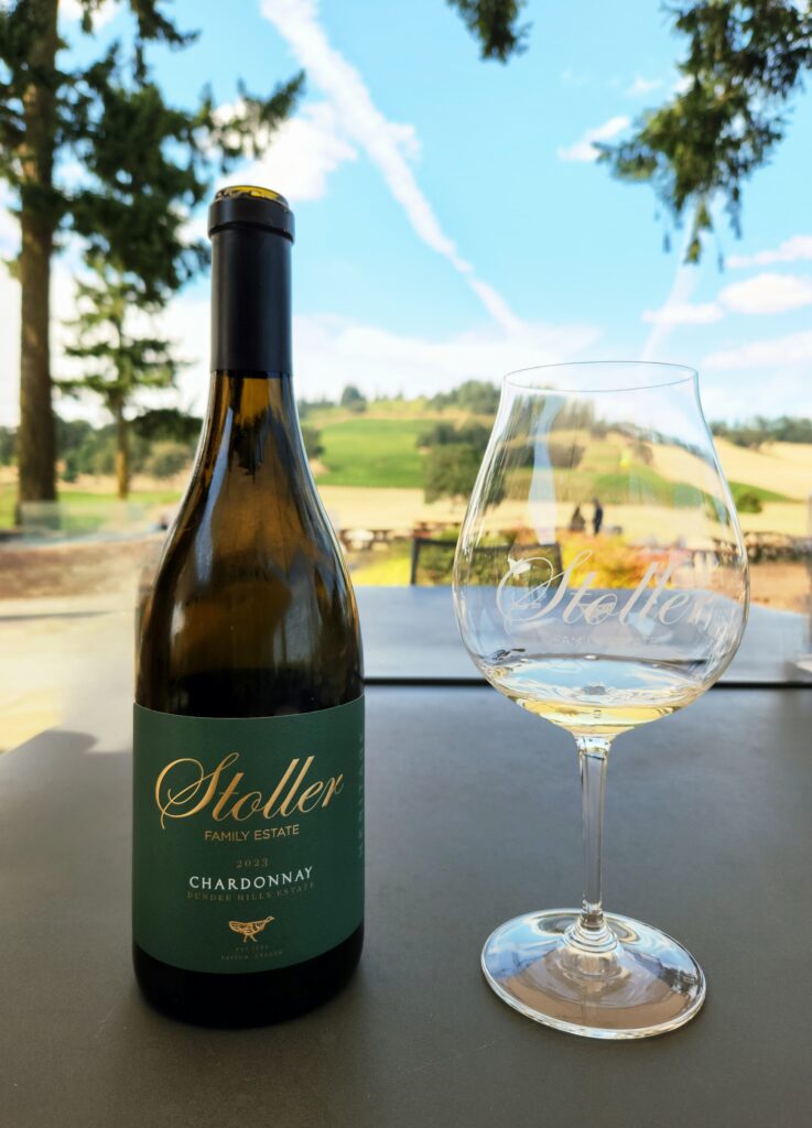 26 Sensational Must-Visit Oregon Wineries in the Willamette Valley 51 A bottle of chardonnay and pour on outdoor table.