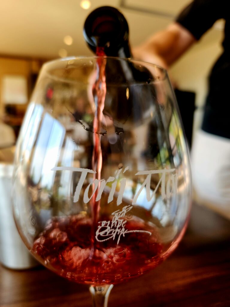 26 Sensational Must-Visit Oregon Wineries in the Willamette Valley 90 Torii Mor red wine being poured into a logo wine glass.