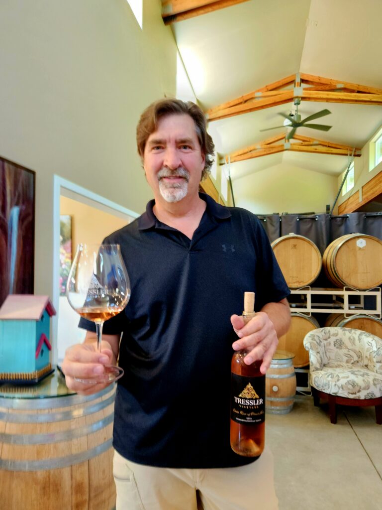 26 Sensational Must-Visit Oregon Wineries in the Willamette Valley 67 Winemaker holding a bottle of his wine and a glass with the tasting.