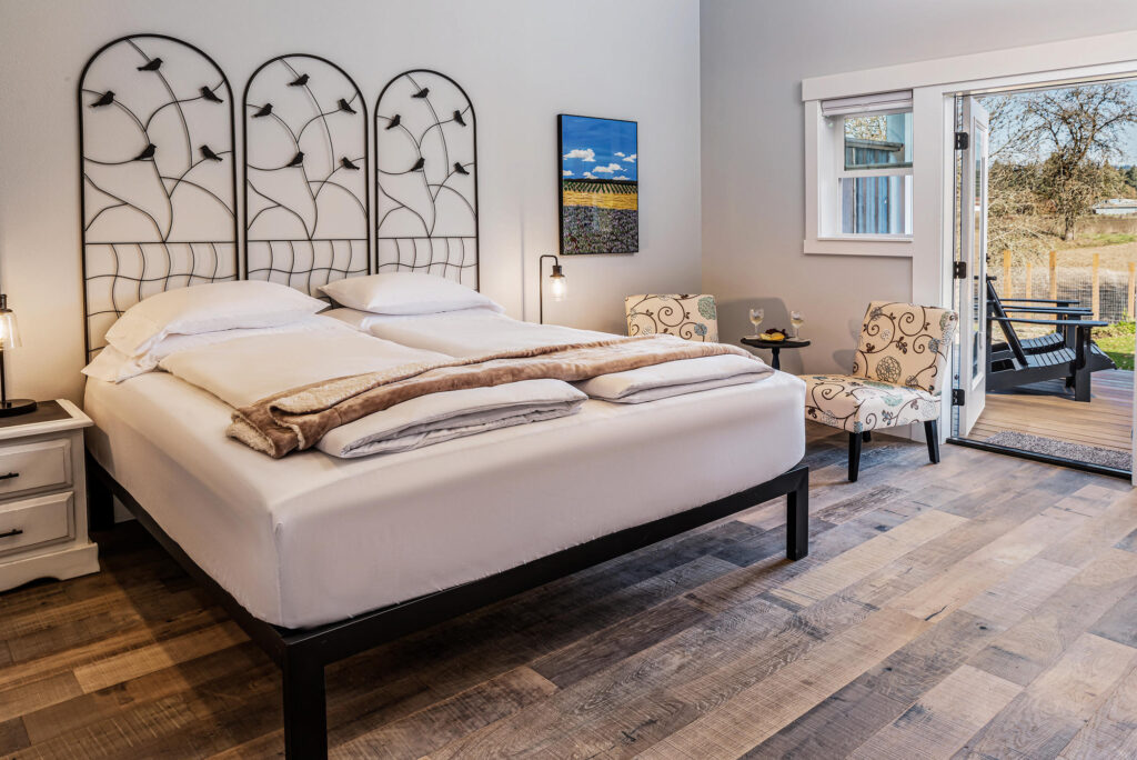 Spend 11 Awesome Days in the Willamette Valley 19 A bed with nightstands and side chairs, with doors opening onto a private patio.
