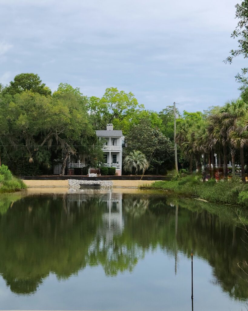 2 Islands, a Lighthouse, & Secret Magic of the Lowcountry 9 A historic house reflected in a pond.