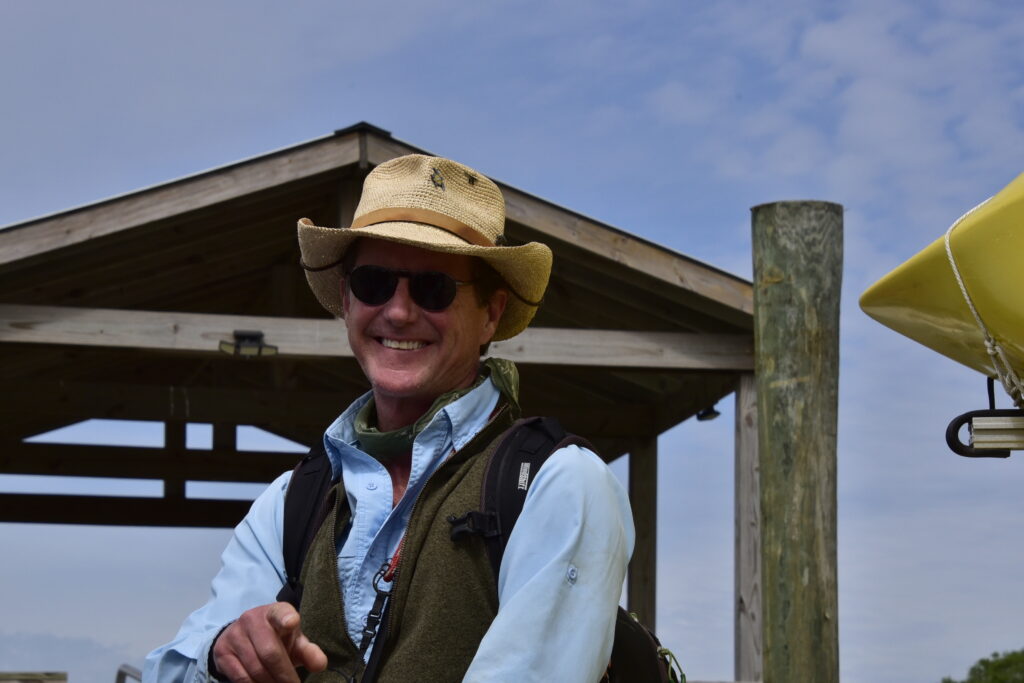 2 Islands, a Lighthouse, & Secret Magic of the Lowcountry 31 Man in hat, smiling and pointing at the photographer.