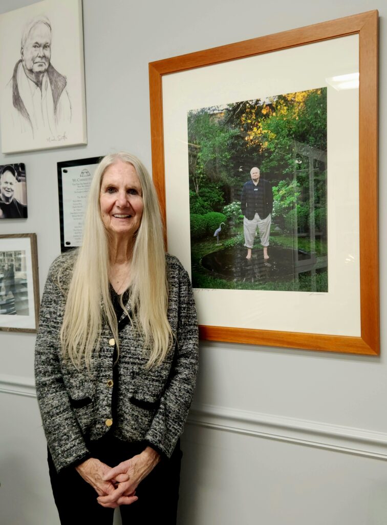 2 Islands, a Lighthouse, & Secret Magic of the Lowcountry 6 Pat Conroy's sister Kathy, standing beside her favorite picture of him--pant legs rolled up, wading in a pond.