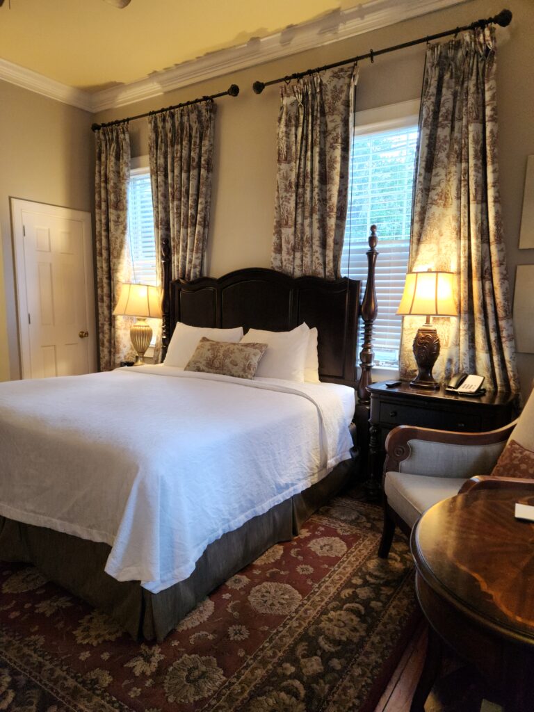 2 Islands, a Lighthouse, & Secret Magic of the Lowcountry 38 Master bedroom with poster bed and sidechair, and oriental carpet.