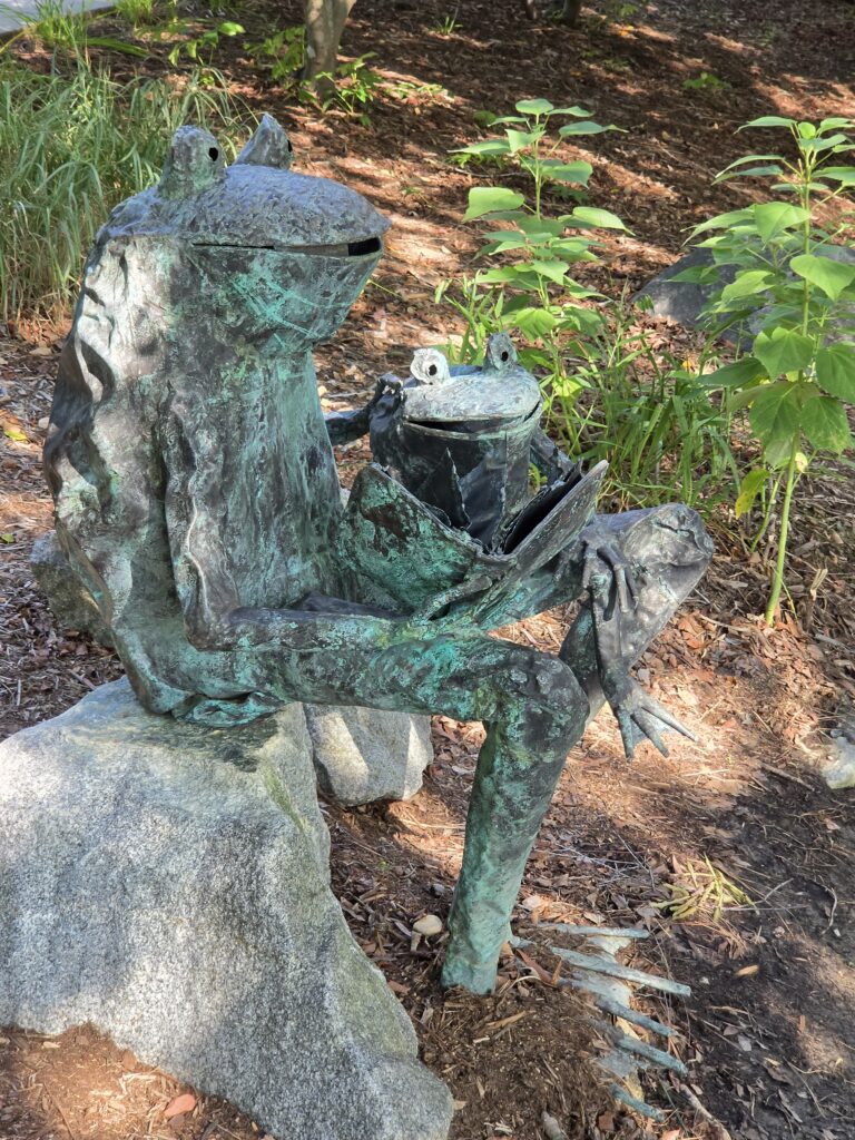 Greensboro: Big, Unexpected Adventures From 1781 Battlefield to Jeansboro 5 Large metal sculptures of frogs reading in the children's garden.