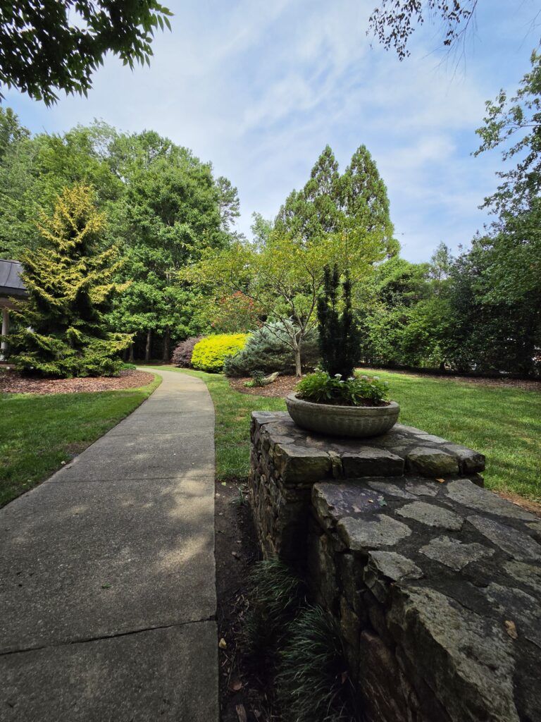 A garden path alongside a stacked rock wall.