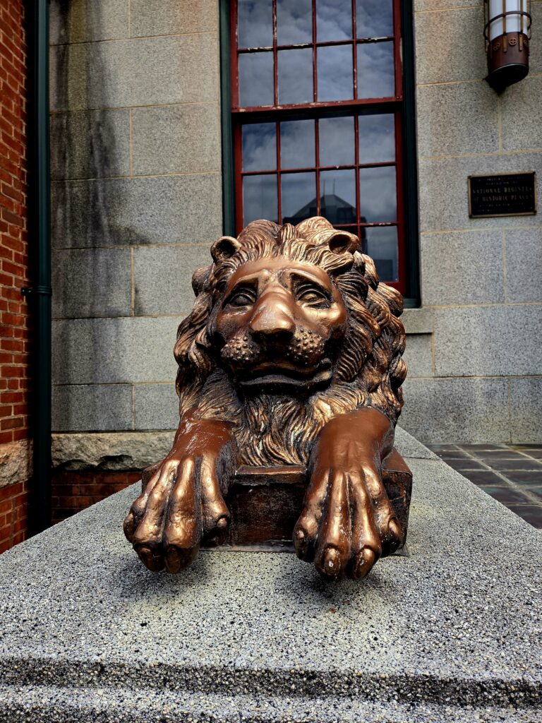 A bronze lion crouches outside the museum.